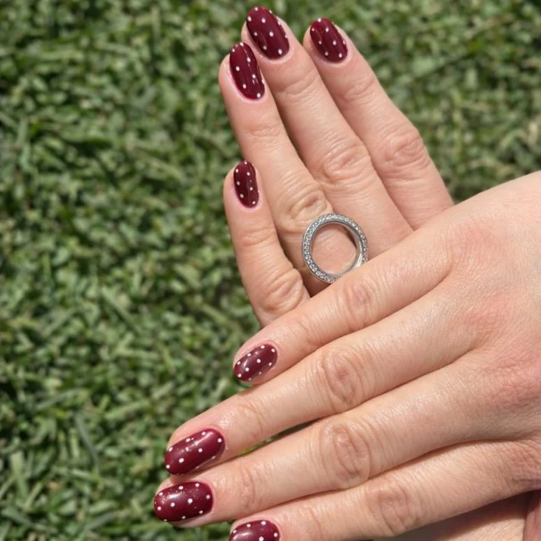 Uñas gelish en vino con puntos blancos a mano alzada, nail art en Guadalajara